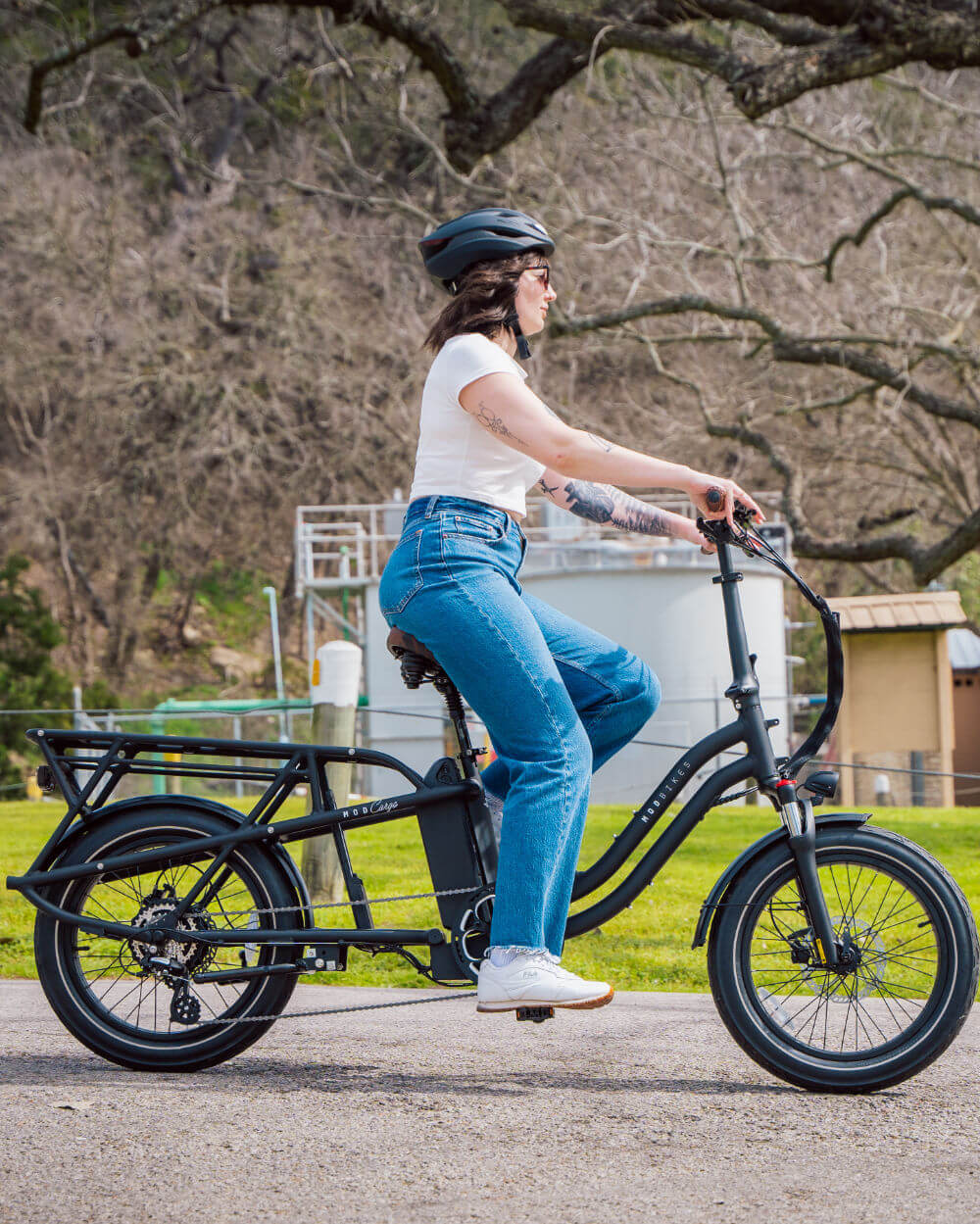 Person riding MOD CarGo 3 e-bike with extended Snap-On rack and sturdy design, showcasing versatility in transporting loads.