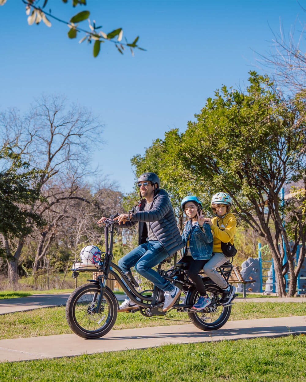 Family riding MOD CarGo 3 bike with Snap-On rack through a sunny park