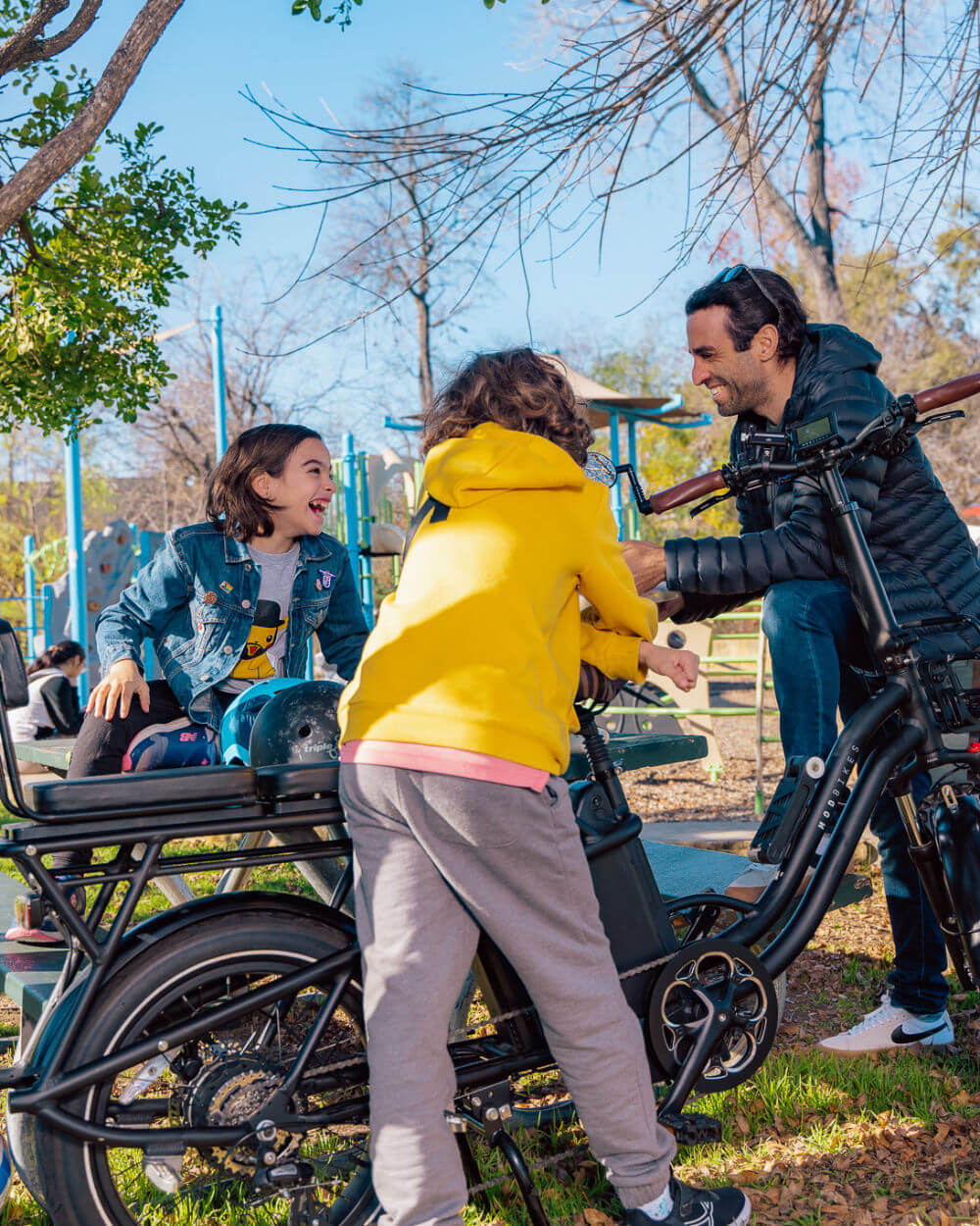 Family enjoying the outdoors with the MOD CarGo 3 bike, featuring a Snap-On rack and dual battery for versatile hauling of passengers.