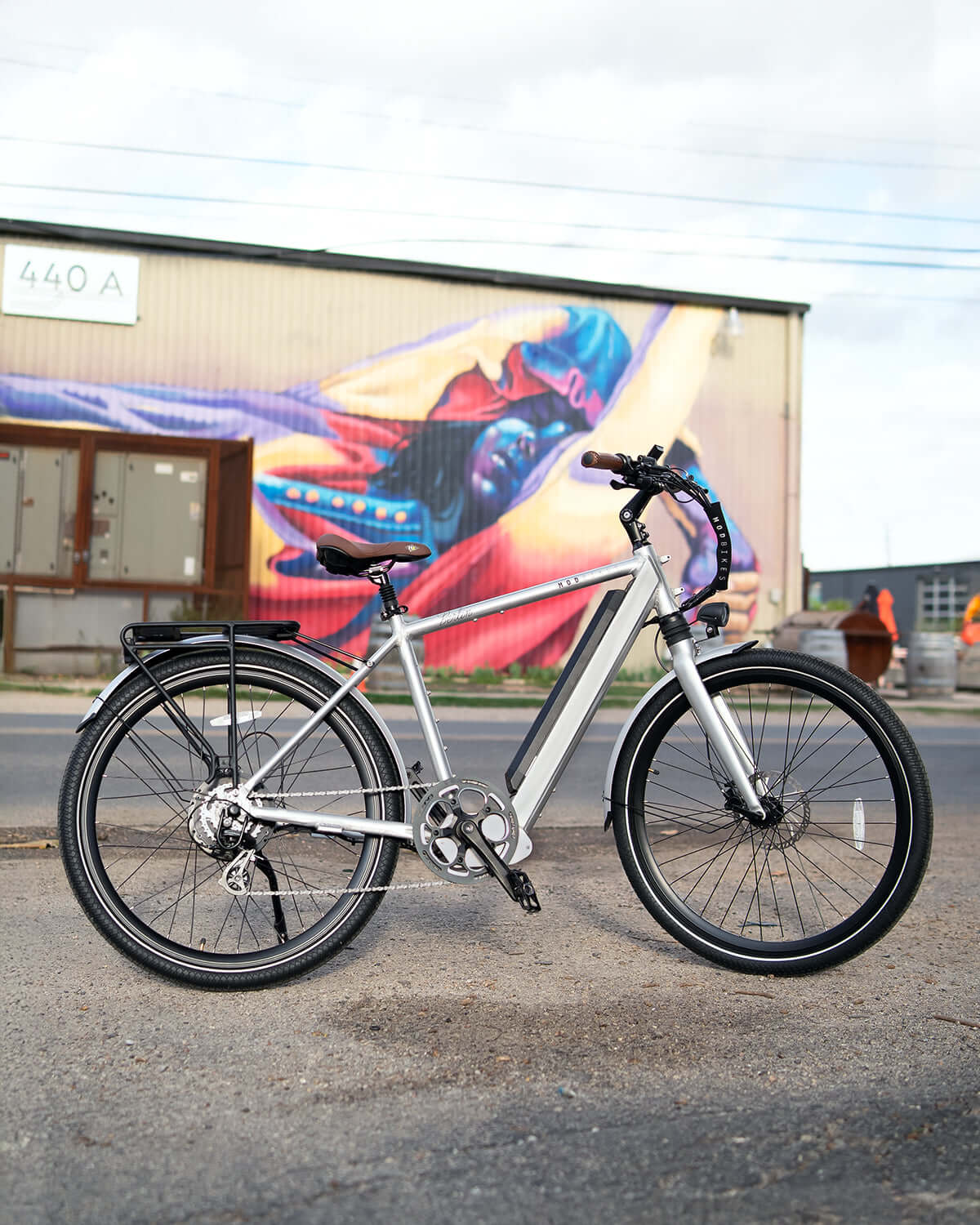 MOD Berlin 3 electric bike with minimalist European design, lightweight frame, and dual suspension, parked outdoors.