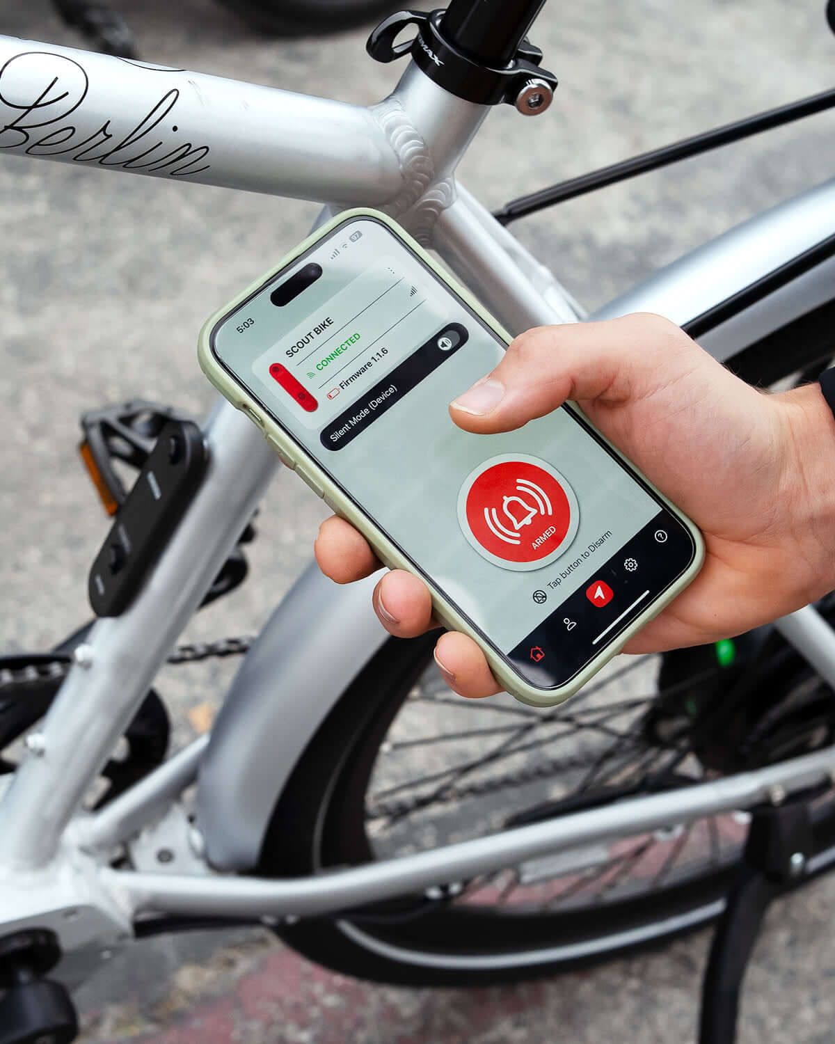 Using Bike Alarm & Finder with Apple Find My app on a smartphone next to a secured bicycle.