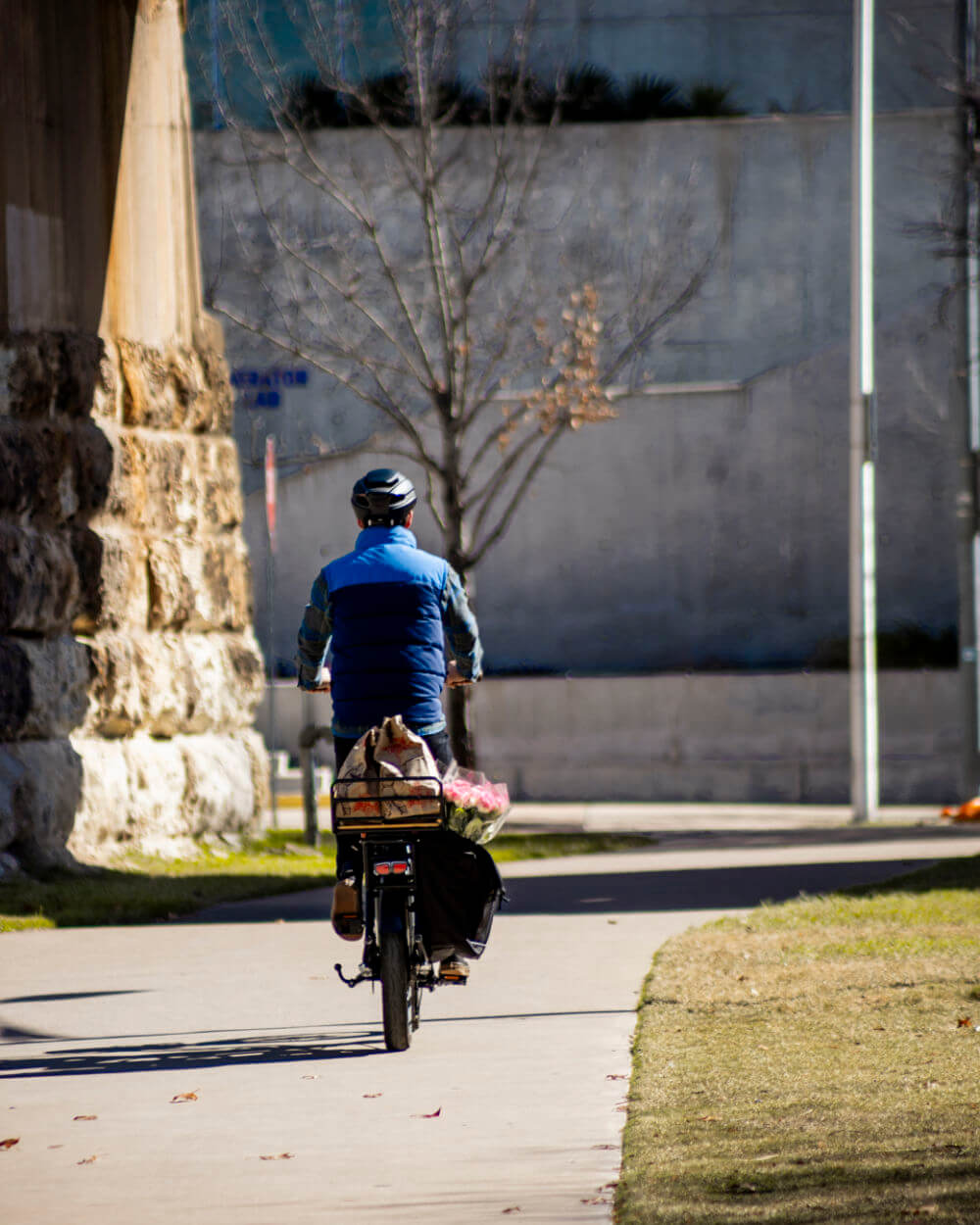 Cyclist riding MOD CarGo 3 with a loaded Snap-On rack for easy transport on a sunny path.
