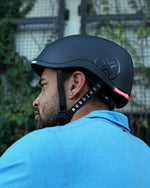 Cyclist wearing a Lumos Nyxel electric helmet for road safety.